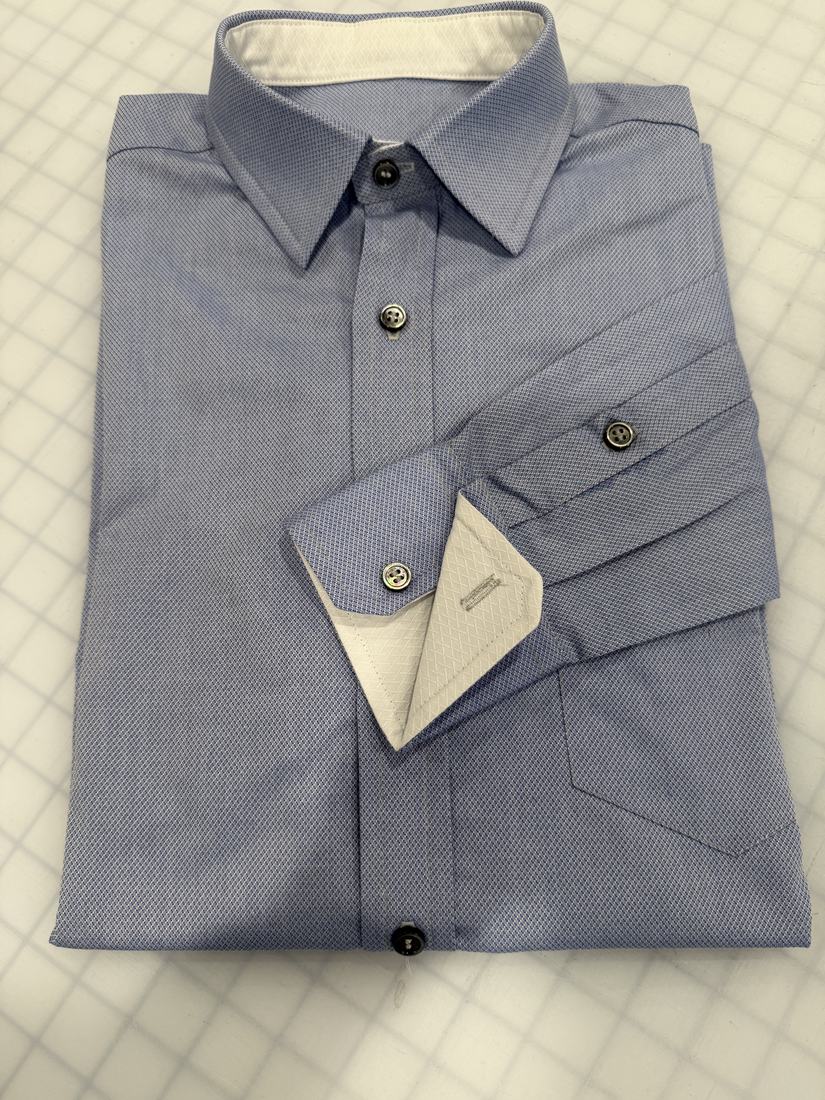 The folded blue shirt with the cuff turned back to show the white contrast facing.