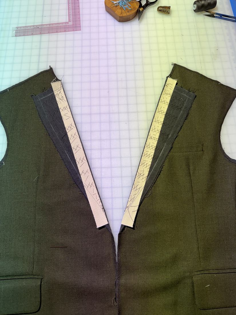 Both jacket fronts laid flat, canvas basted in and the lapel roll line taped.